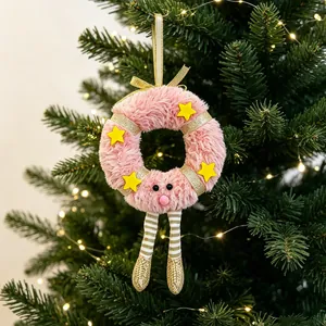 Pink plush Christmas wreath ornament with gold stars and striped legs on a tree