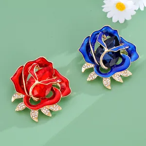 Exquisite crystal rose brooches in red and blue with rhinestones on green background