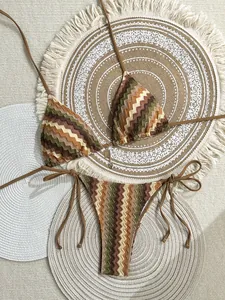 Detail of crochet knit bikini with wavy stripes, halter top, and gold pendant accessory