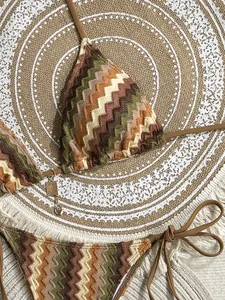Detail view of chevron stripe knit bikini set with gold heart charms and metal accents