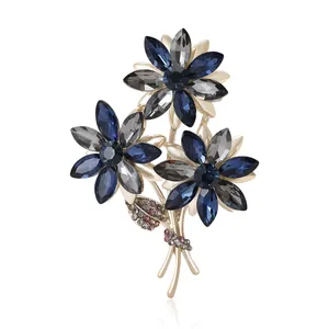 Elegant floral bouquet brooch with blue and grey crystals on a rose gold base