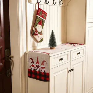 Chemin de table de Noël avec gnomes et carreaux buffalo sur un meuble blanc élégant