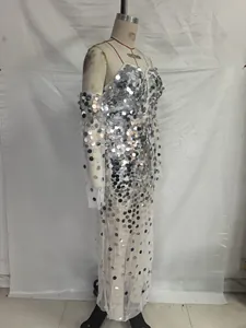 Macro detail of sparkling silver sequins on white sheer mesh evening gown with sleeves