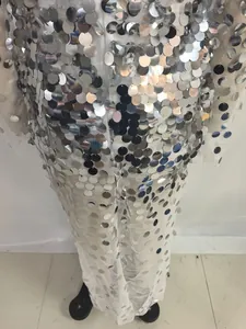 Close-up of white mesh evening gown featuring large silver sequins for party events