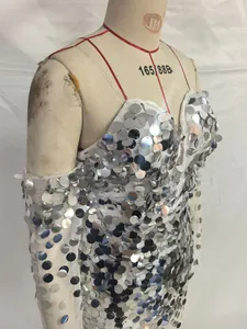 Detailed view of large silver sequins sewn on a white mesh formal evening dress