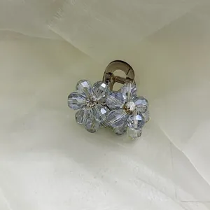 Elegant light blue crystal flower hair claw clip with golden wire on brown base