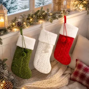 Calze di Natale in maglia con bordo in peluche e pompon su un davanzale festivo