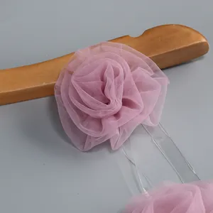 Dettaglio del fiore in tulle rosa con petali 3D stratificati sulla vestaglia