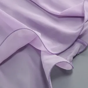 Dettaglio del tessuto velato lavanda con delicato orlo a rullo sull'abito da sera