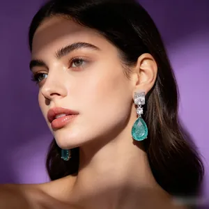 Elegant pear-cut Paraiba blue drop earrings with silver metal on a model, purple background