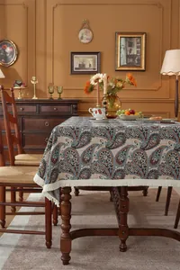 Close-up of vintage paisley jacquard fabric with elegant cream fringe tassels on edges