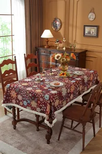 Close-up of vintage floral tablecloth with intricate flower patterns and white tassel fringe