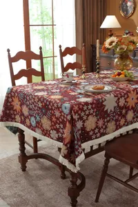 Detail of vintage floral jacquard tablecloth with elegant white fringe tassels