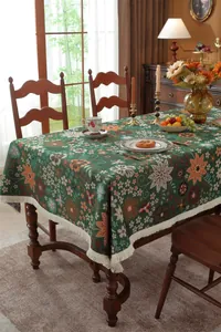 Close-up of vintage floral jacquard tablecloth with elegant cream fringe and botanical motifs