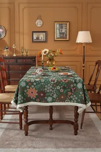 Detail of vintage floral jacquard tablecloth with cream fringes and botanical patterns