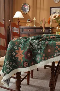 Detail of vintage jacquard tablecloth with colorful floral patterns and white fringe edge