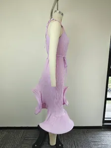 Détail de robe plissée lavande montrant l'ourlet à volants et la taille nouée