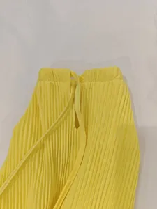 Détail d'une jupe plissée jaune vif avec taille élastique et cordon de serrage