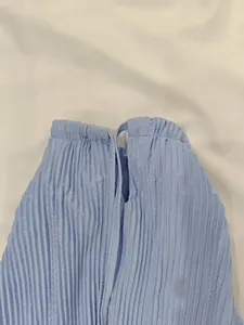 Détail du tissu plissé bleu clair avec encolure licou et smocks élastiques
