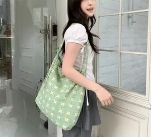 Detail of green floral canvas tote bag with small yellow and white flower patterns