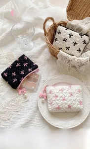 Detailed view of ruffled bow coin purses in black and white with pearl charms