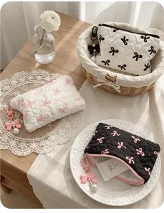 Quilted bow makeup bag collection with pearl zipper charms in three contrast colorways