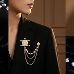 Eleganter Gold-Schneeflocken-Brosche mit Perlen und Ketten auf schwarzem Sakko