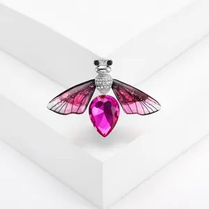 Macro detail of crystal bee brooch showing the pink pear-shaped gem and gradient wings
