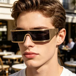 Gros plan de lunettes de soleil carrées futuristes avec monture en métal doré mat sur modèle