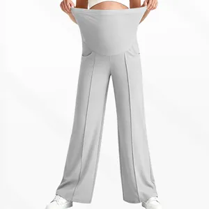 Detail showing elastic high-waist support band on light grey maternity wide leg trousers