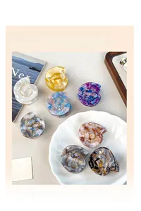 Detailed view of acetate shell hair claw clips with marble textures and gold spiral