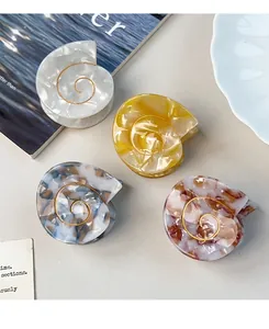 Detailed view of conch acetate hair claws with marble texture and pearl luster