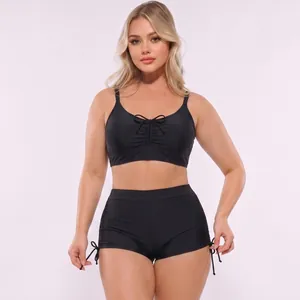 Detail of black two-piece swimsuit with ruched drawstring top and high-waisted shorts