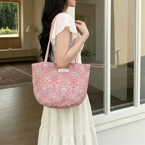Détail du sac cabas à fleurs roses en toile épaisse avec des bretelles tissées élégantes