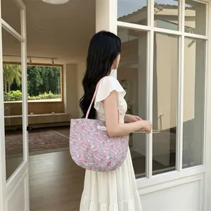 Détail du motif floral et de l'étiquette sur un sac cabas en toile violette chic