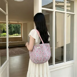 Gros plan du sac cabas en toile à fleurs avec imprimé lilas et étiquette de marque