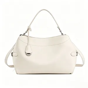 Detailed view of cream-white handbag with silver D-ring hardware and smooth leather texture