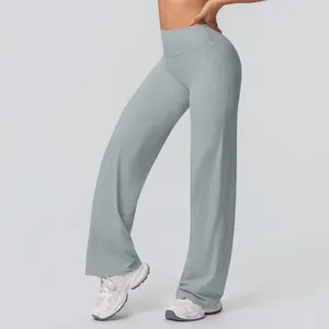 Detail view of high-waist yoga pants in light sage green with wide leg cut and elastic fabric