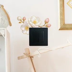 Detail of camellia wall sticker with gold edges on a black light switch plate