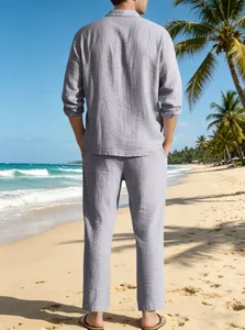 Détail de l'ensemble chemise et pantalon en lin gris clair sur fond de plage tropicale