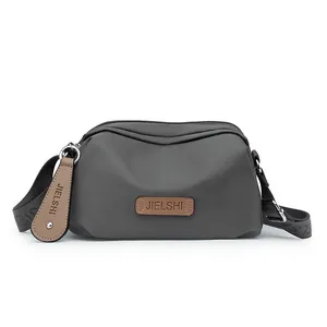 Waterproof dark grey oxford crossbody bag with adjustable strap and multiple zip pockets