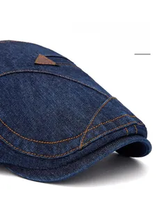 Gros plan d'une casquette en denim bleu avec coutures jaunes et détail en cuir