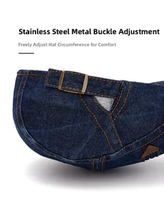 Détail de la boucle en métal et des coutures orange sur la casquette en denim bleu