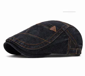 Détail d'une casquette gavroche en denim noir délavé avec empiècement cuir et coutures