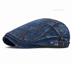 Détail d'une casquette en denim bleu avec coutures en zigzag orange et boucle latérale