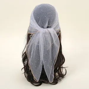 Detail of grey mesh headscarf featuring colorful rhinestones and gold wavy edges