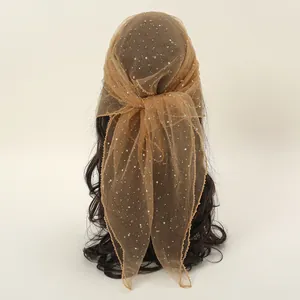 Close-up of brown mesh headscarf with sparkling rhinestones and detailed edging