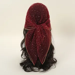 Macro detail of burgundy lace bandana with silver rhinestones and gold wave edging