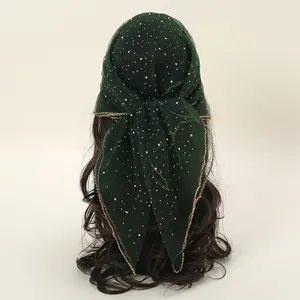 Detailed view of a dark green mesh headscarf with sequins and gold stitching