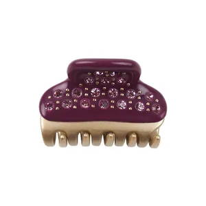 Detail view of small hair claw clip with purple resin and pink rhinestones inlay